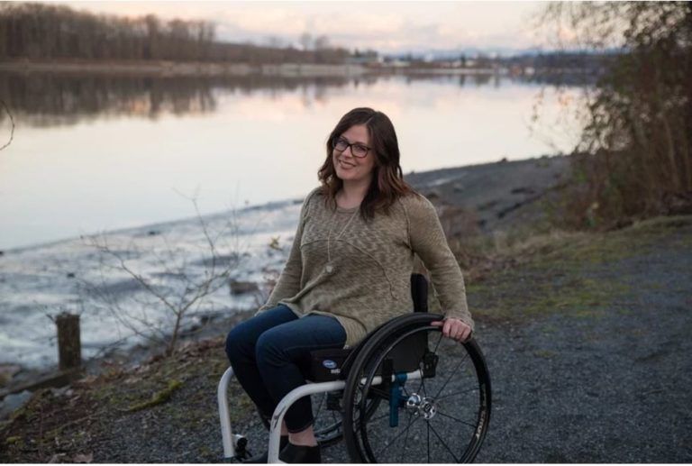 Una donna con disabilità sulle sponde di un corso d’acqua.