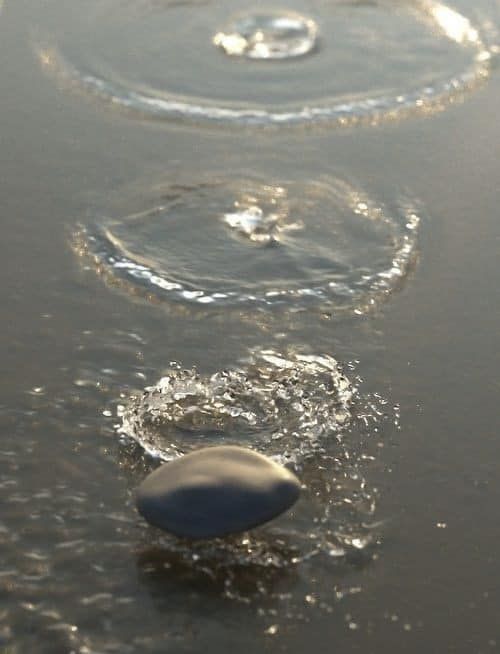 Un sasso compie alcuni salti sulla superficie dell’acqua generando piccoli cerchi concentrici.