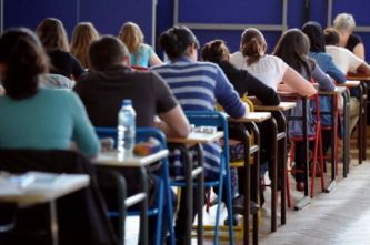 Studenti in classe, fotografati di spalle.