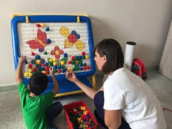 Un’operatrice lavora con un bambino con autismo utilizzando la terapia ABA (Analisi Applicata del Comportamento).