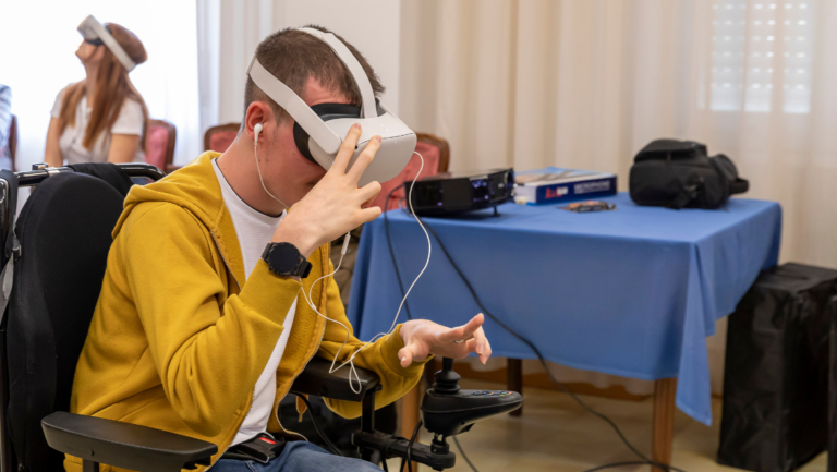 Un giovane uomo con disabilità motoria mentre utilizza un visore per la realtà virtuale.